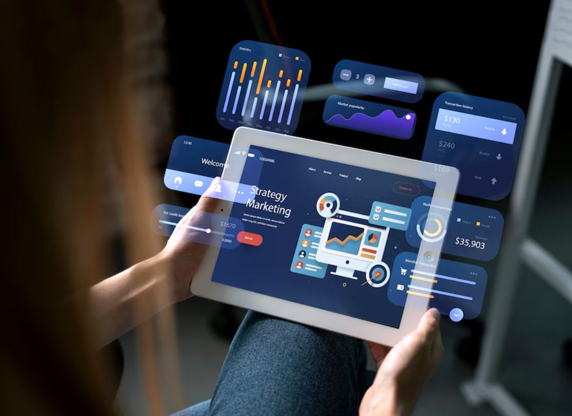 A woman is holding a tablet displaying various colorful icons, showcasing technology and digital interaction